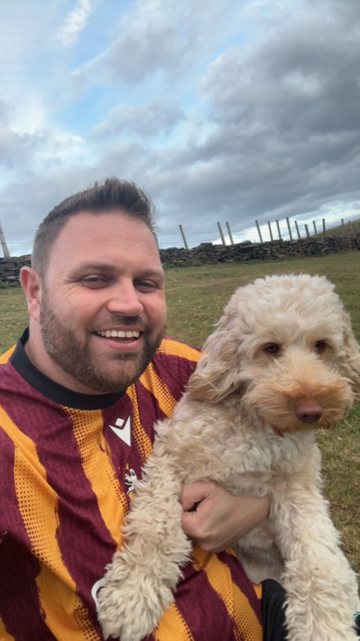 Michael in a Bradford City shirt with his cockapoo